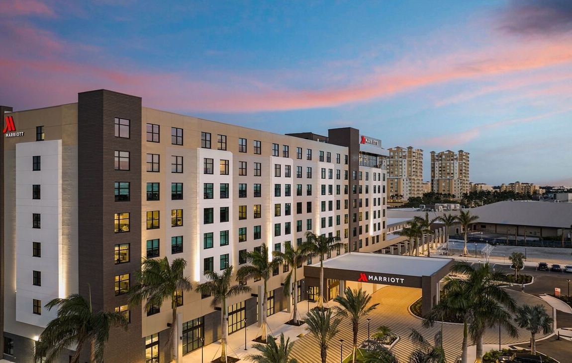 Exterior view of the Palmetto Marriott Resort & Spa building at dusk with palm trees and ambient lighting.