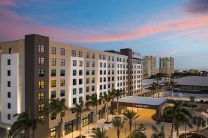 Exterior view of the Palmetto Marriott Resort & Spa building at dusk with palm trees and ambient lighting.
